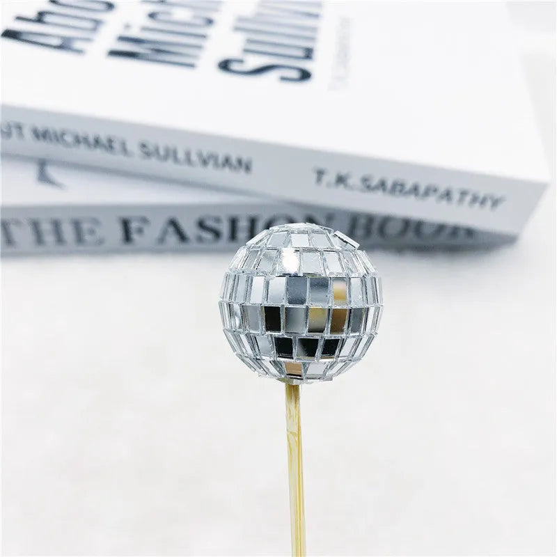 Glass disco ball cake decoration on a wooden stick, shown in different sizes.
