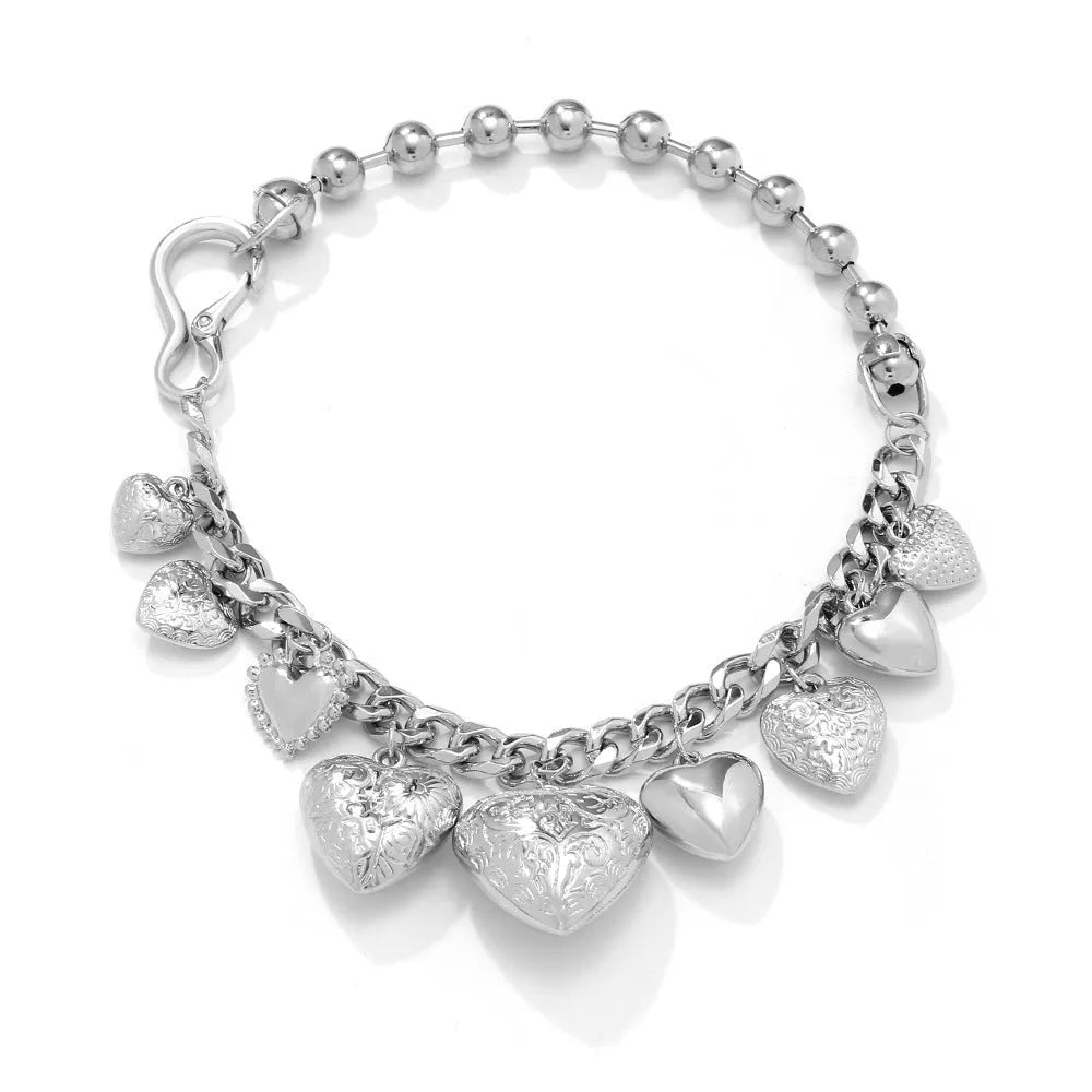 Carved heart-shaped alloy pendant on a metal chain necklace in gold colour.