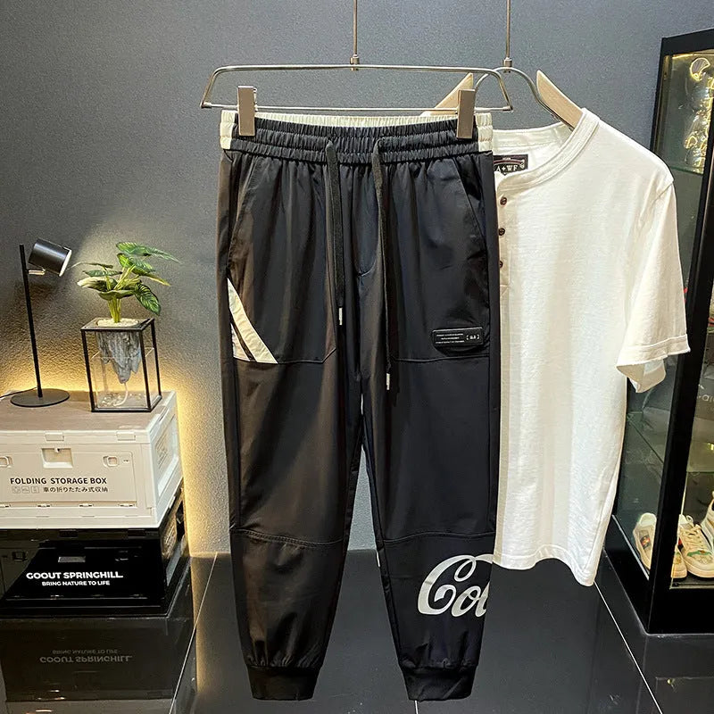 Men's solid black cotton cropped trousers with ankle banded style on hanger