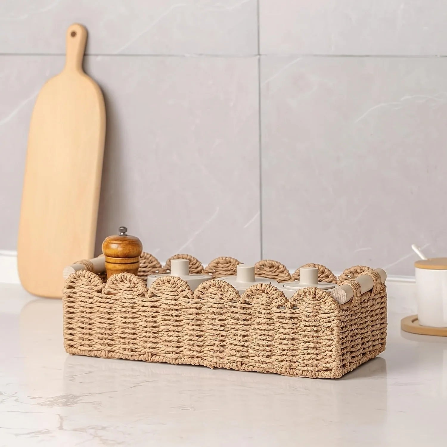 Rectangular woven paper storage basket in a choice of colours on a wooden table.