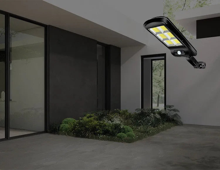 Black outdoor solar-powered motion sensor security light mounted on a wall.
