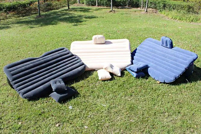 Black inflatable car bed with flocking surface and two pillows, shown folded next to a storage bag.