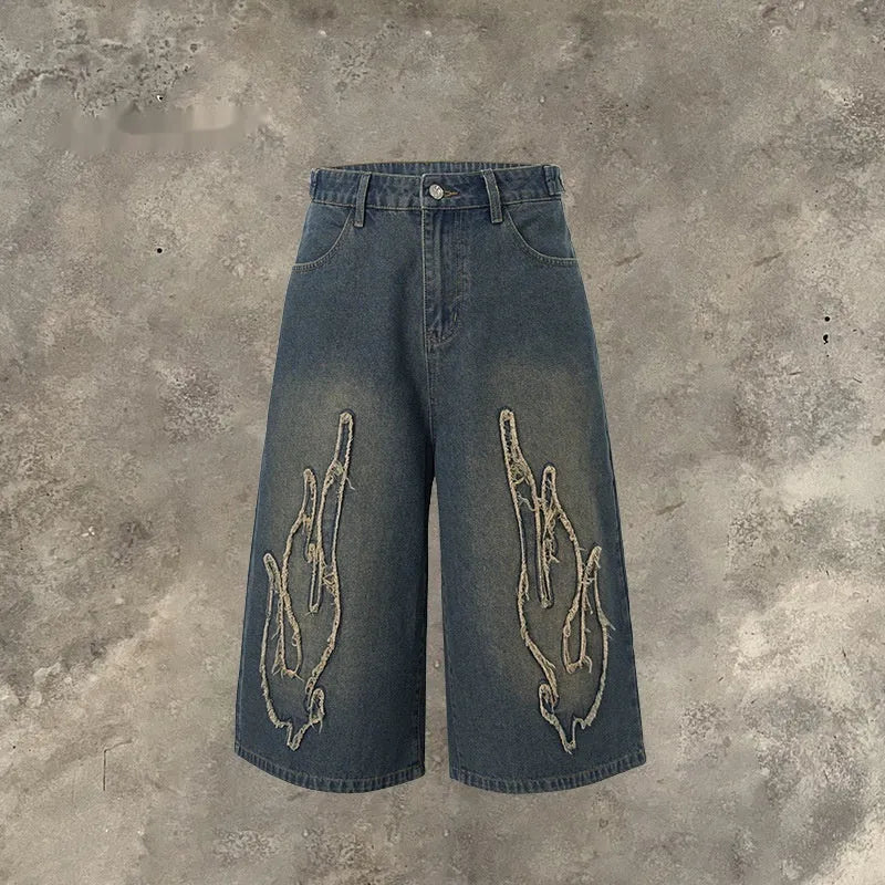 Men's black denim shorts with flame embroidery patch detail, cropped length and straight leg street style