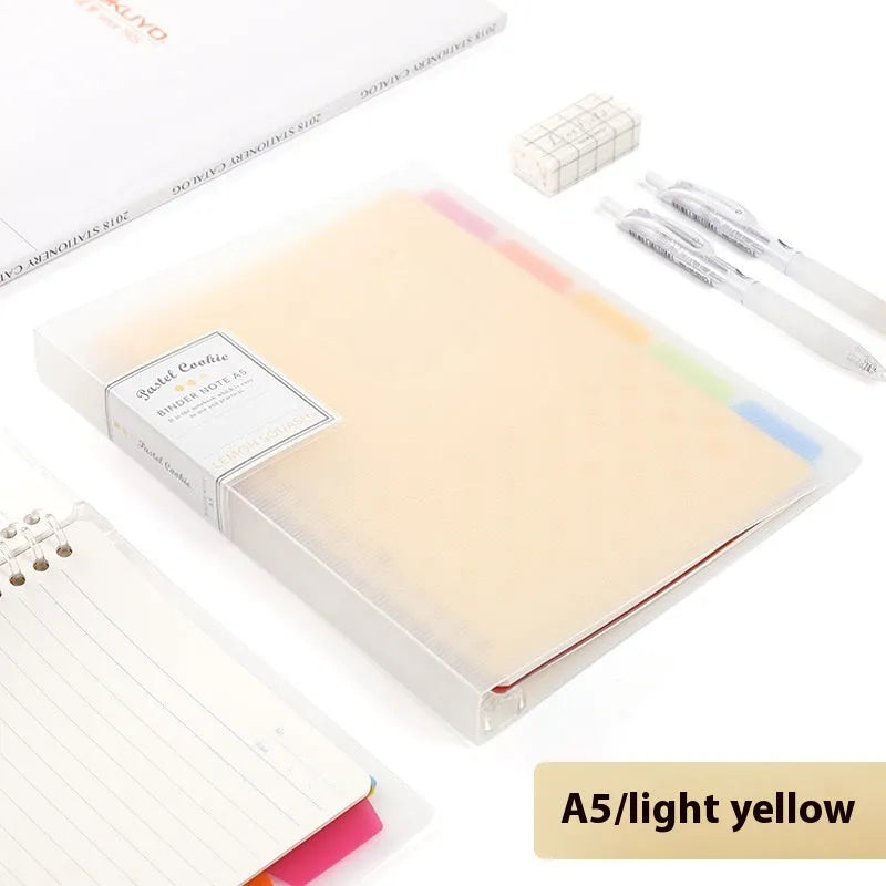 Refillable loose-leaf spiral notebook with PP cover open, showing raw wood pulp paper in grid ruling.