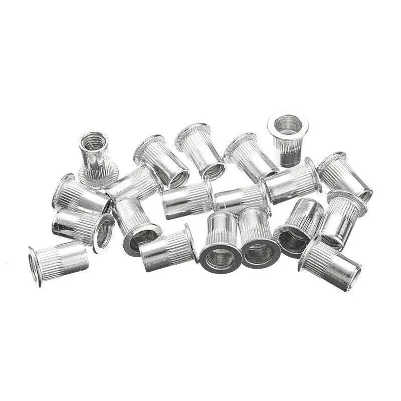 Manual hand riveter gun with an assortment of alloy steel rivet nuts and mandrels on a workbench.