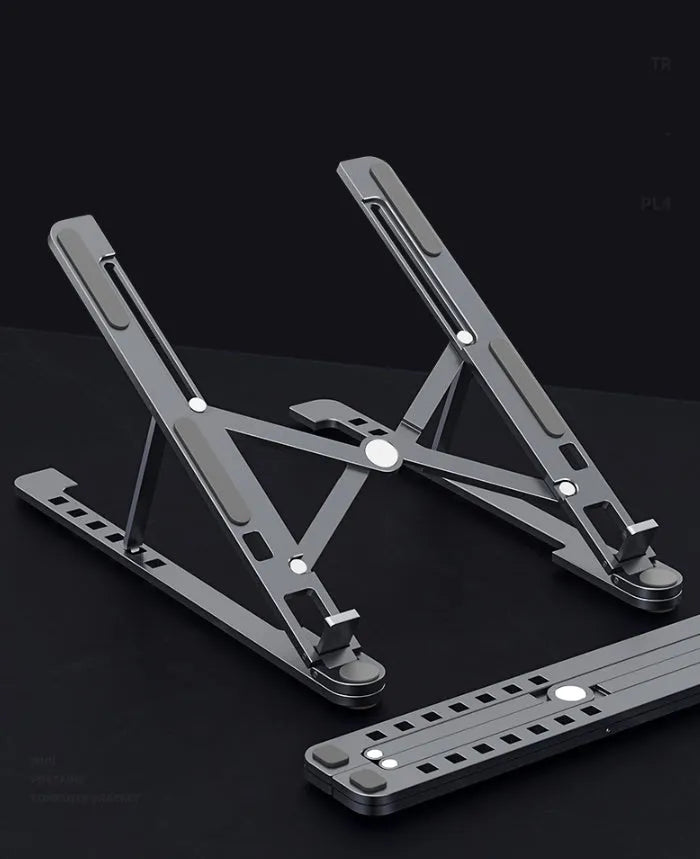 Aluminium laptop stand in silver colour, folded flat next to an open laptop for size comparison.
