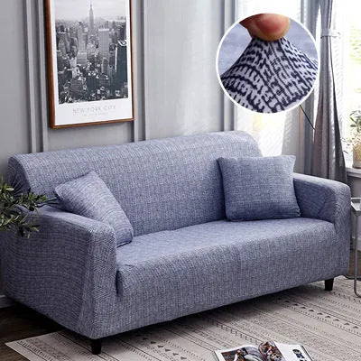 Geometric abstract printed stretch sofa slipcover covering a three-seater sofa with matching cushion covers.