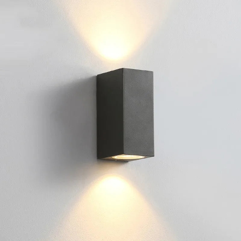 Satin black aluminium and glass LED wall lamp mounted on an interior wall.