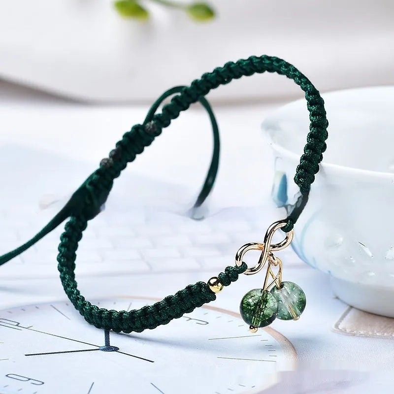 Women's natural strawberry quartz bracelet with a fruit-shaped crystal charm on wrist.