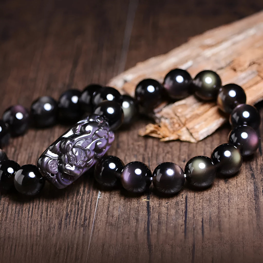 Polished natural crystal Pi Xiu bracelet with geometric beads on a wrist.