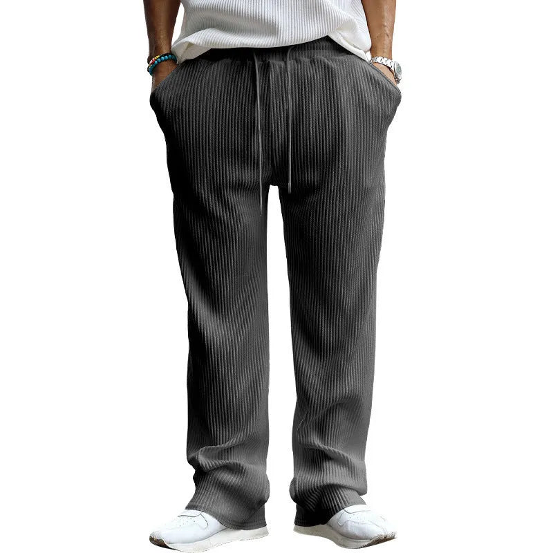 Man wearing loose-fit, high-waist, straight-leg casual trousers in a striped pattern.