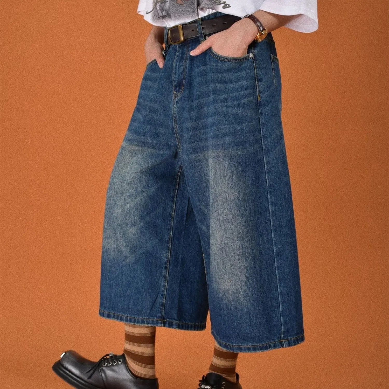 Man wearing blue loose straight-leg denim shorts with a simple summer style.