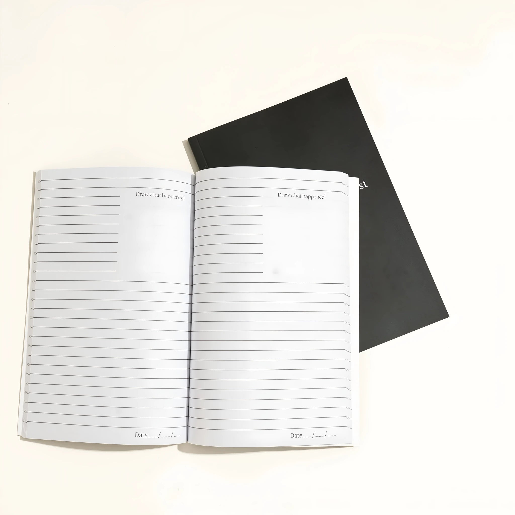Black softcover Dream Journal notebook open on a table