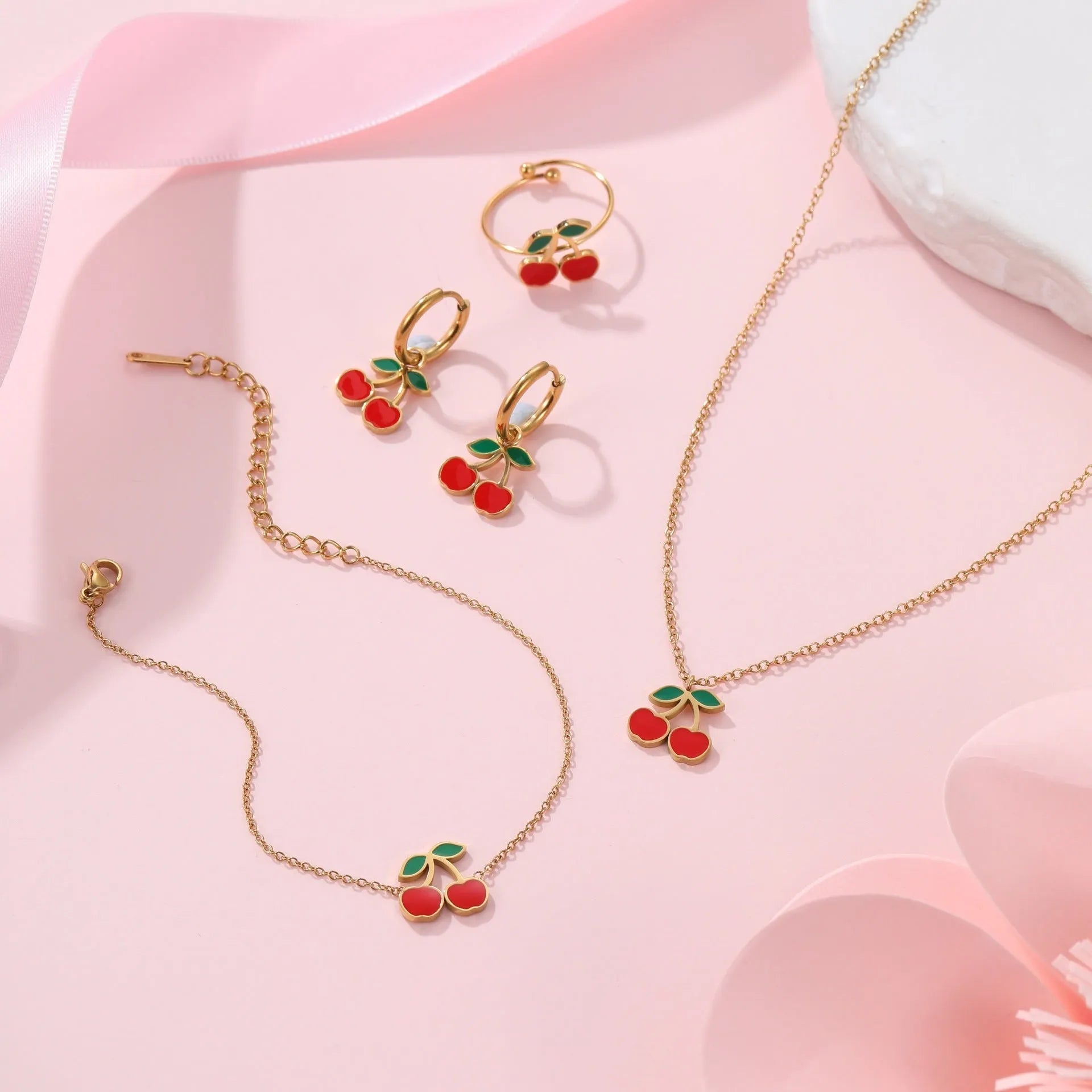 Cherry jewellery set showing necklace, bracelet, earrings, and ring with stainless steel construction and 18K gold electroplated finish