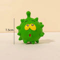 Set of four colourful latex squeaky dog balls with cute faces on a textured surface.