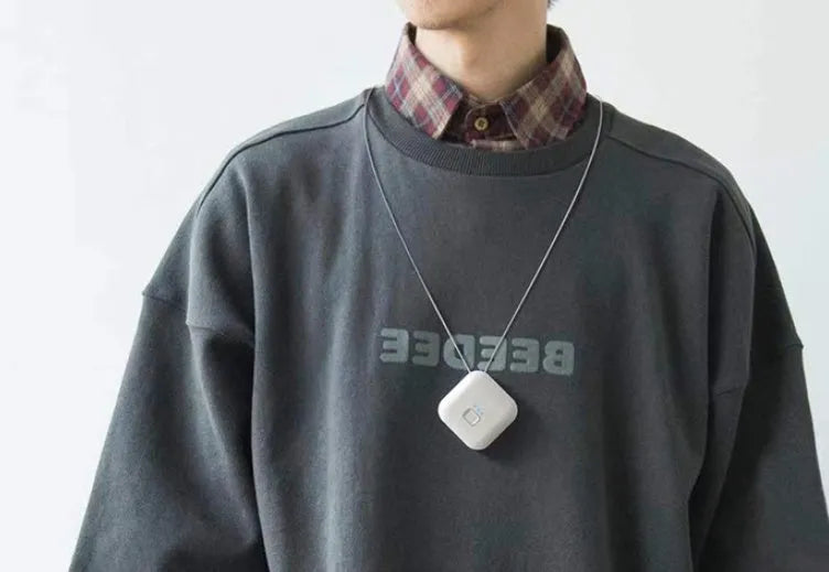 Mini USB portable air purifier necklace in pink, showing compact design with a wearable collar.
