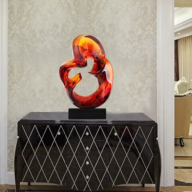 Modern transparent resin craft ornament in orange red and blue colour options on a plain background.