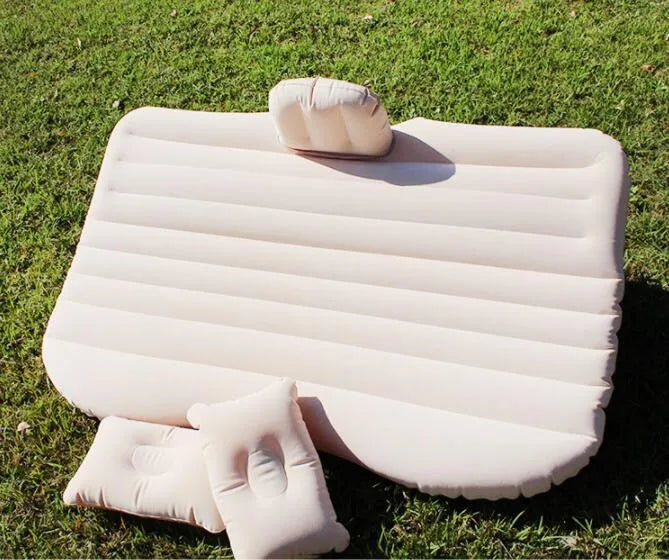 Black inflatable car bed with flocking surface and two pillows, shown folded next to a storage bag.