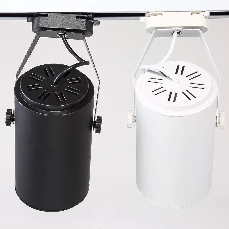 Black aluminium LED track spotlight with sliding head mounted on a track for wall lighting.