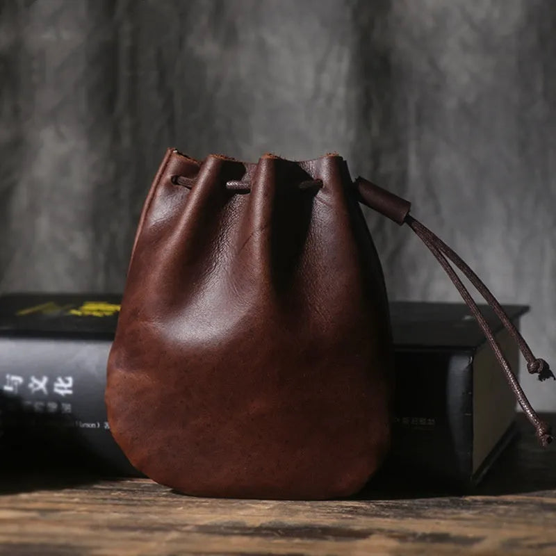 Vintage cowhide drawstring bundle wallet in genuine leather showing retro style and sewing thread detail.