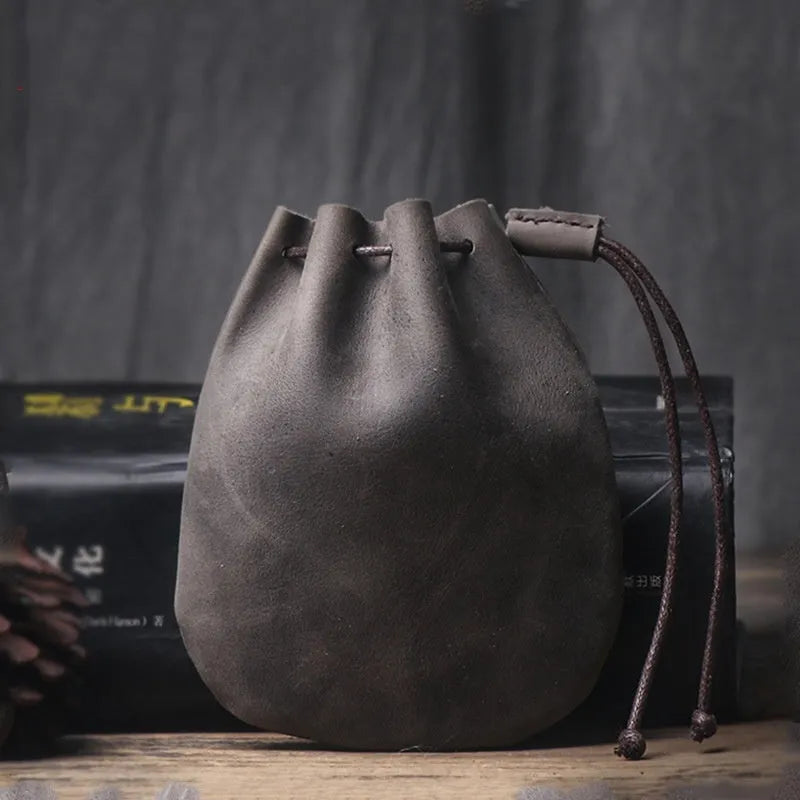 Vintage cowhide drawstring bundle wallet in genuine leather showing retro style and sewing thread detail.