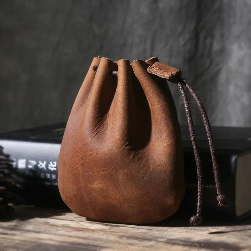Vintage cowhide drawstring bundle wallet in genuine leather showing retro style and sewing thread detail.