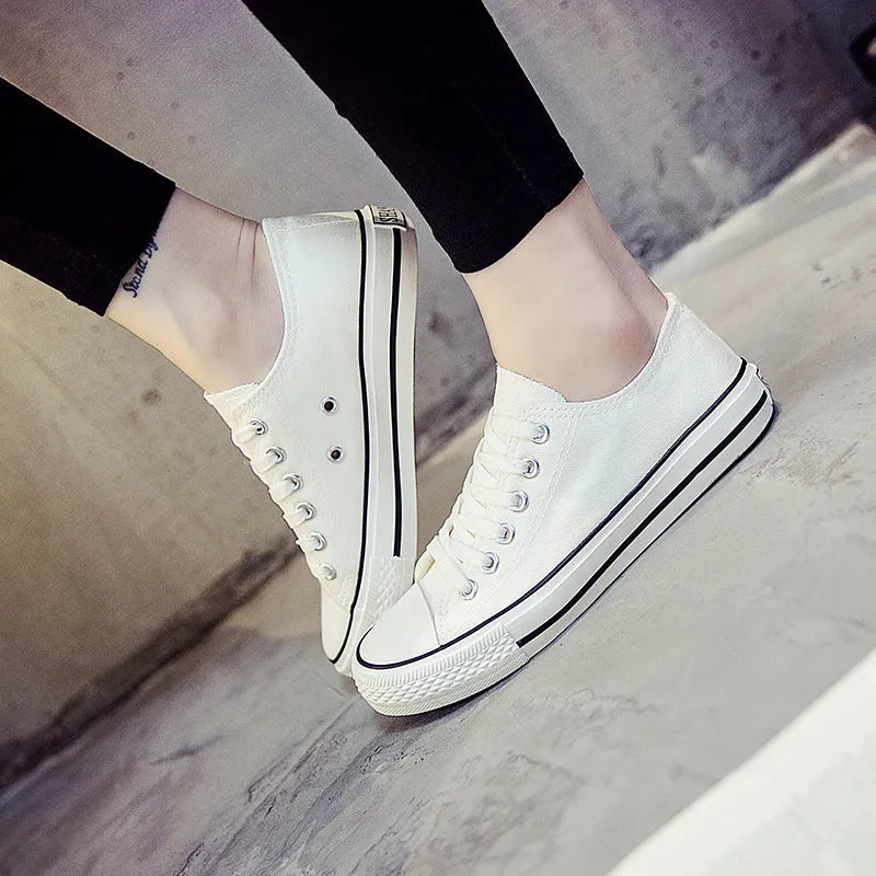 Women's solid colour canvas slip-on shoes in black, white, and red variations on a plain background.