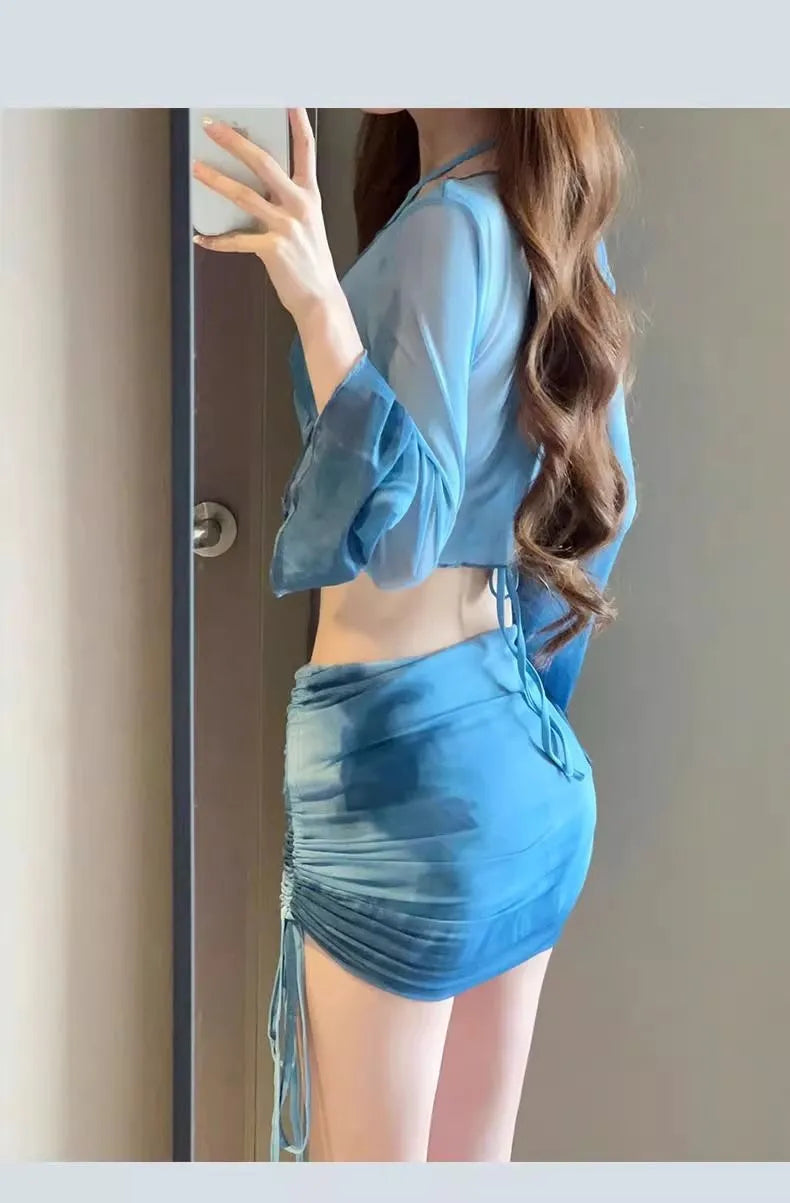 Women's blue four-piece bikini set with high-waist briefs, backless top, and coordinating skirt