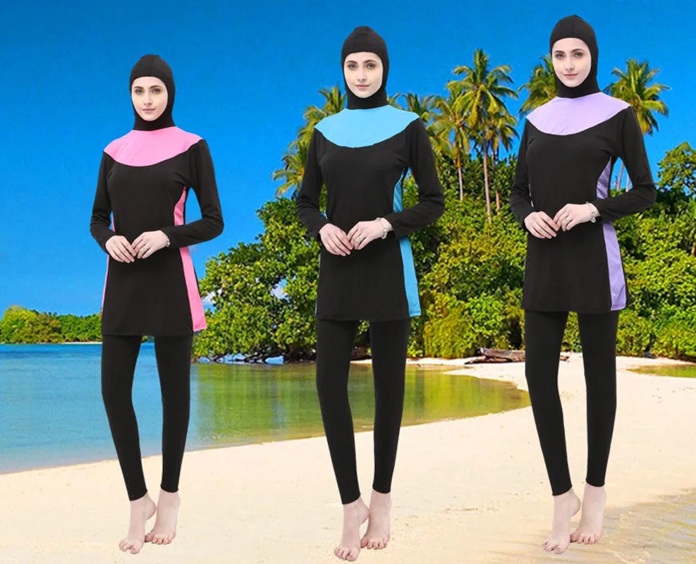 Women's black long sleeve hooded swimsuit with separate pants, shown on a model.