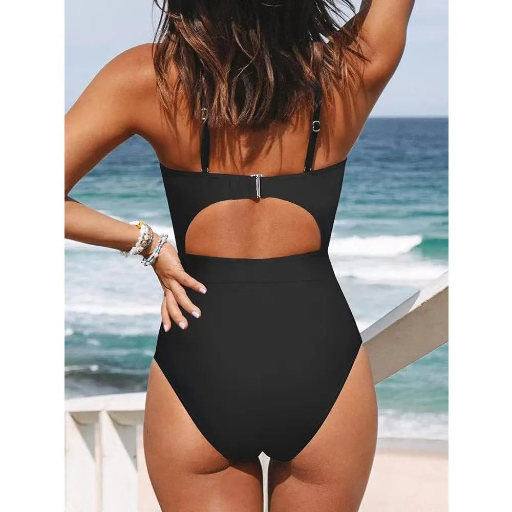 Women's black cross-back one-piece swimsuit with backless design and solid colour pattern