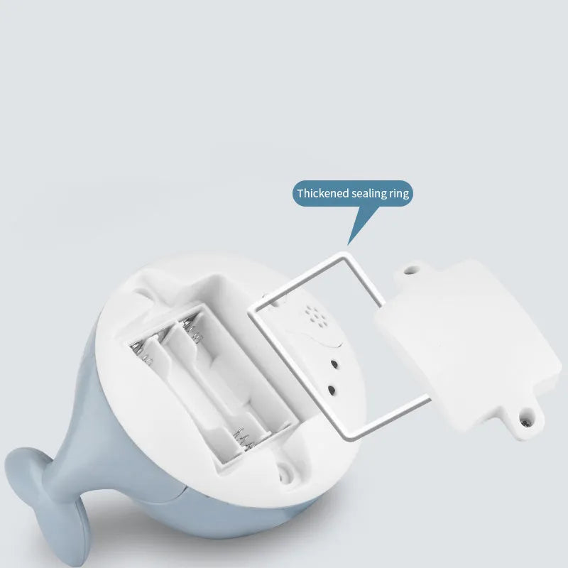 Electric whale-shaped baby bath toy with water spray, LED lights, and automatic water sensor