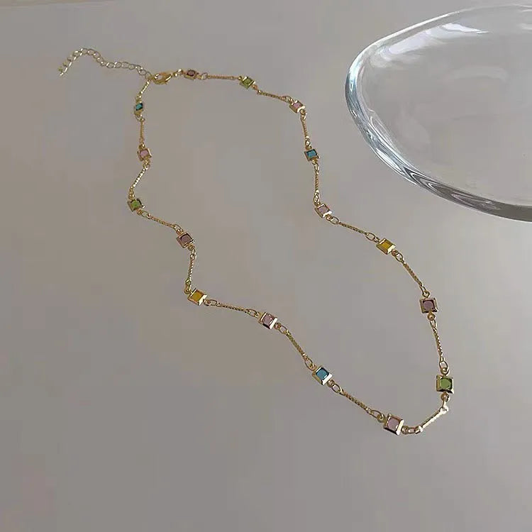 Square colour clavicle chain necklace with geometric quadrilateral links and artificial crystal detailing in gold finish
