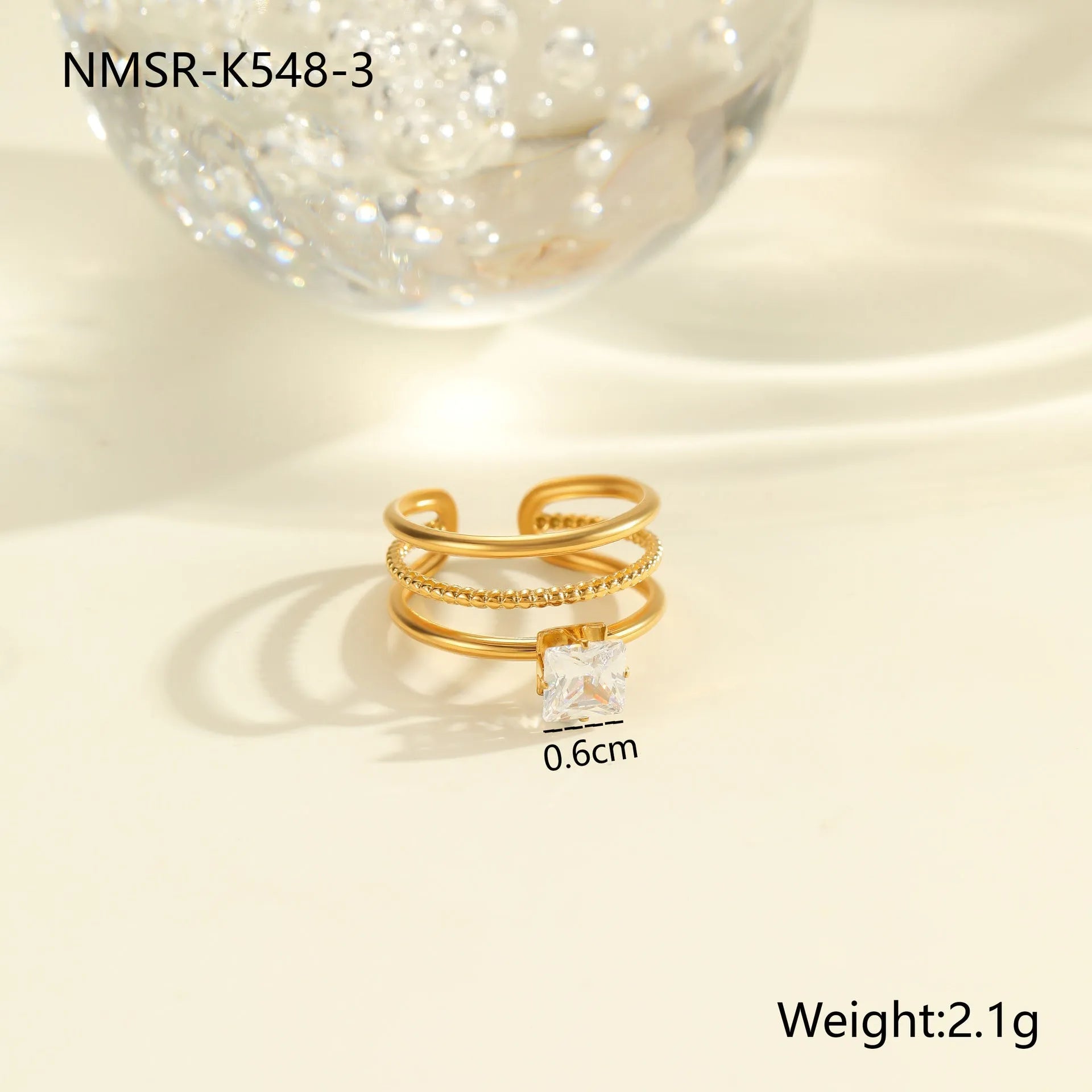 Gold inlaid zircon geometric heart and drop shape stainless steel ring on white background.