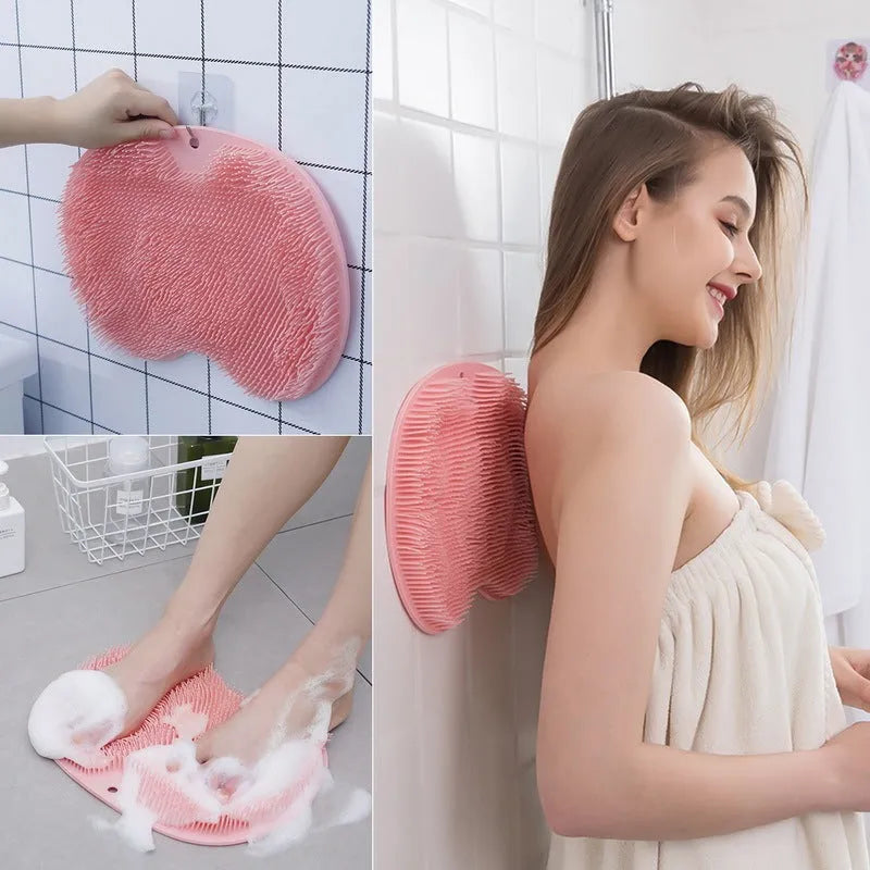 Orange suction cup bath brush with silicone bristles for foot and back cleaning on a bathroom floor.