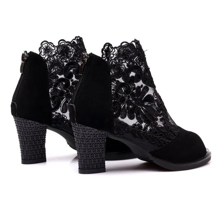 Black women's gladiator sandals with floral lace upper, high square heel, and a front zip closure.