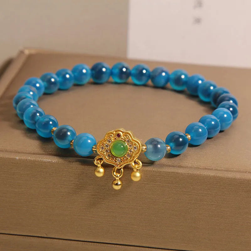 Blue sugar heart agate safety lock pendant on a crystal women's bracelet with rhinestone details.