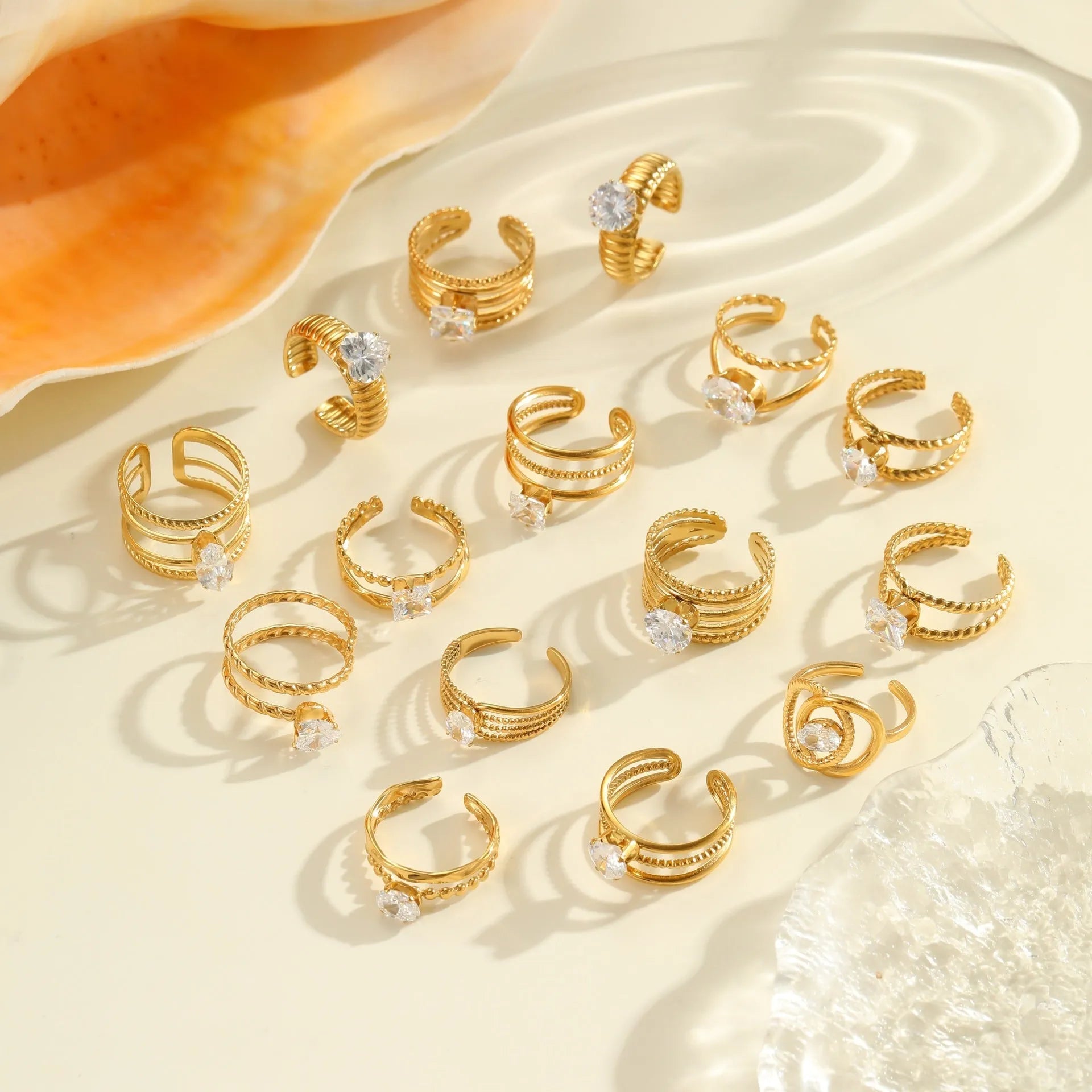 Gold inlaid zircon geometric heart and drop shape stainless steel ring on white background.