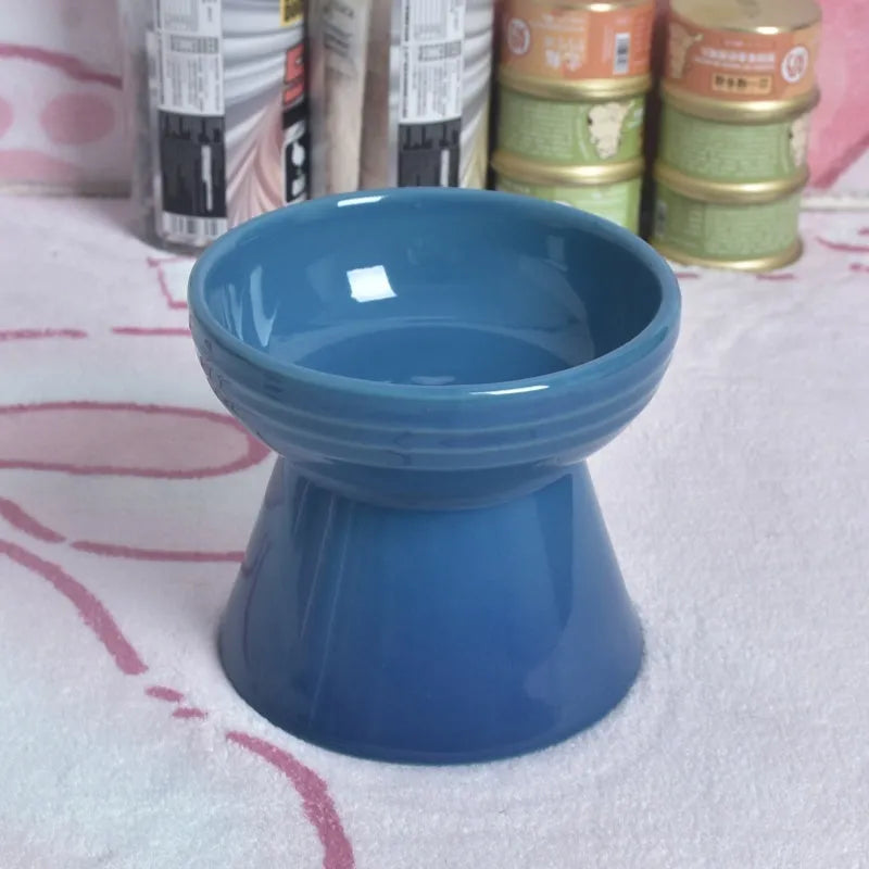 Black ceramic pet bowl with a chin-high foot and raised neck protector on a white background.