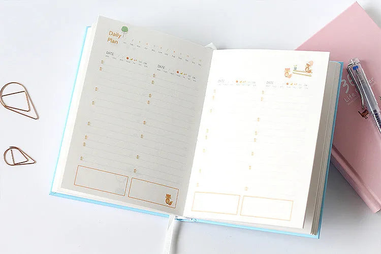 Hardback colour inside notebook planner with 228 pages, open to daily schedule, shown in Dark Green
