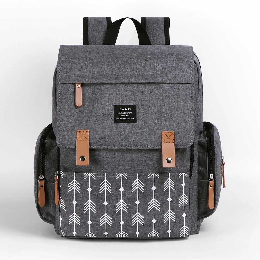 LAND Mommy large grey diaper backpack with changing mat, shown with baby care items.