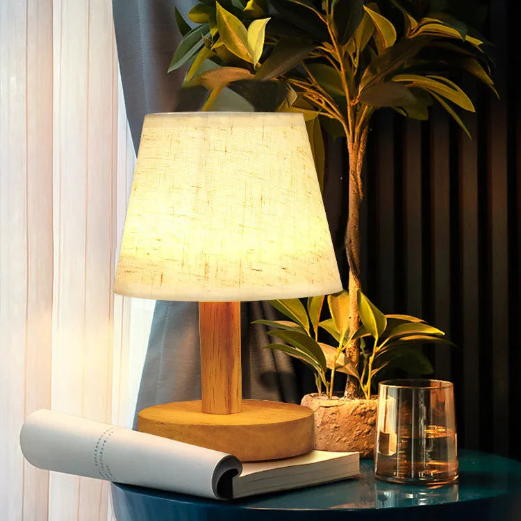 Vintage pleated table lamp with jute shade and bamboo base on a wooden table.
