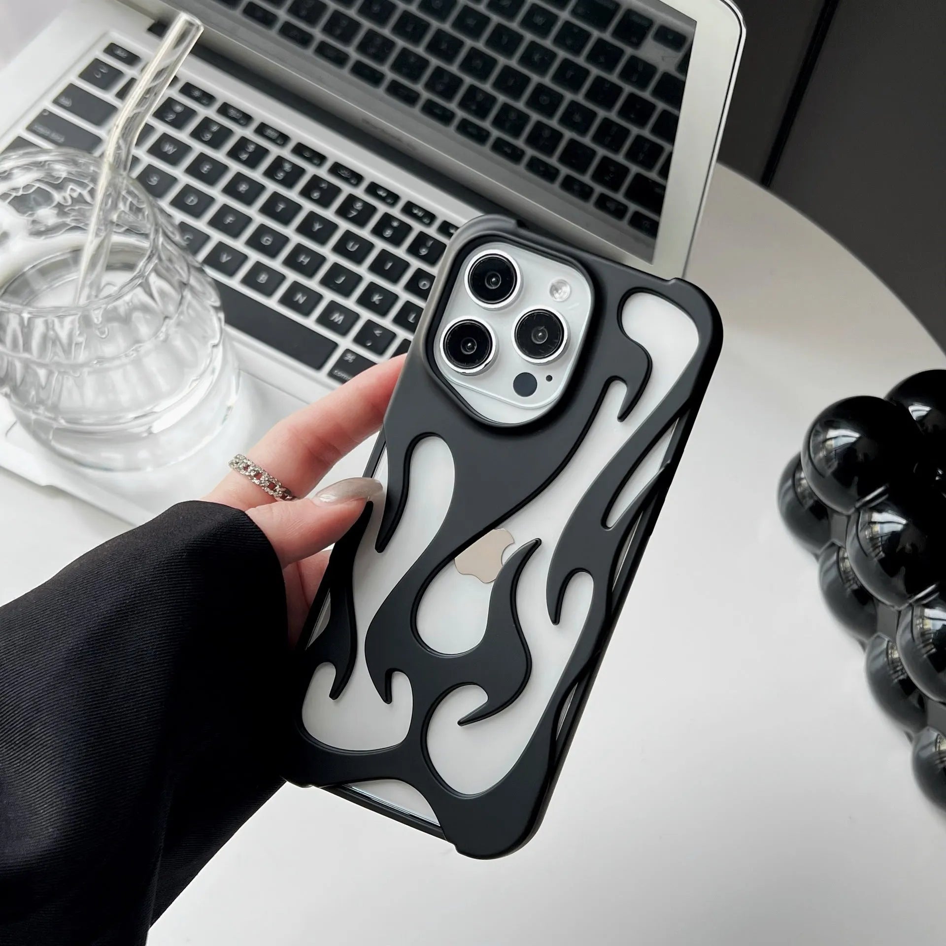 Electroplated hollow flame pattern TPU iPhone case in silver plating shown on a phone.