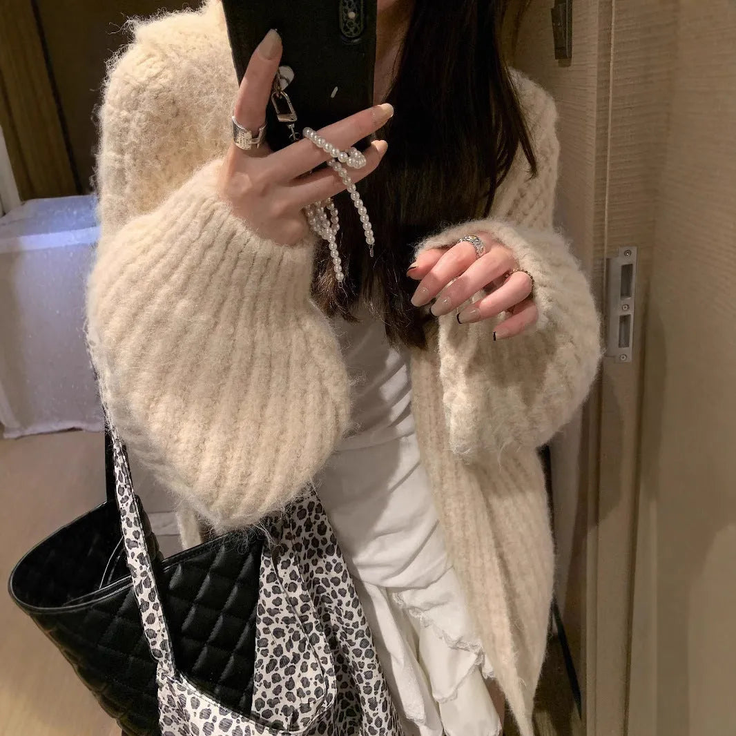 A woman's dark grey hooded cardigan with long sleeves, shown open in a loose fit.