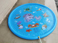 Blue PVC children's water spray mat with marine animal designs laid on grass