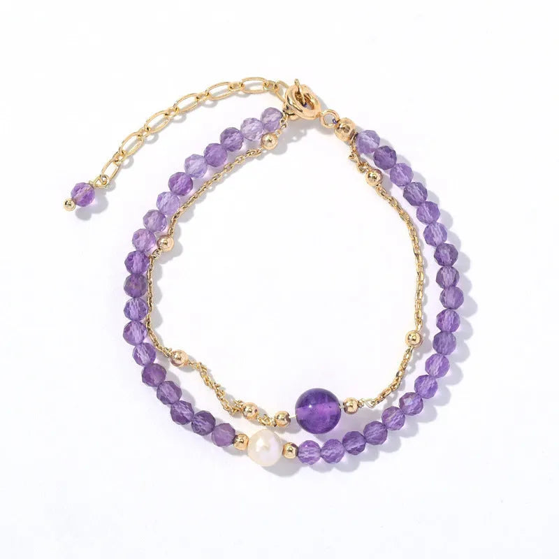 Close-up of a Chinese style women's bracelet with a diamond-shaped amethyst crystal on an electroplated chain.