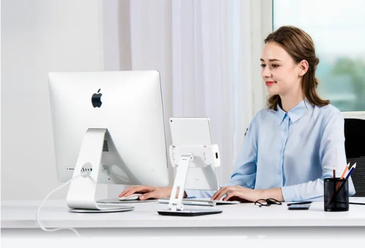 Silver foldable aluminium stand holding a tablet at an angle on a desk
