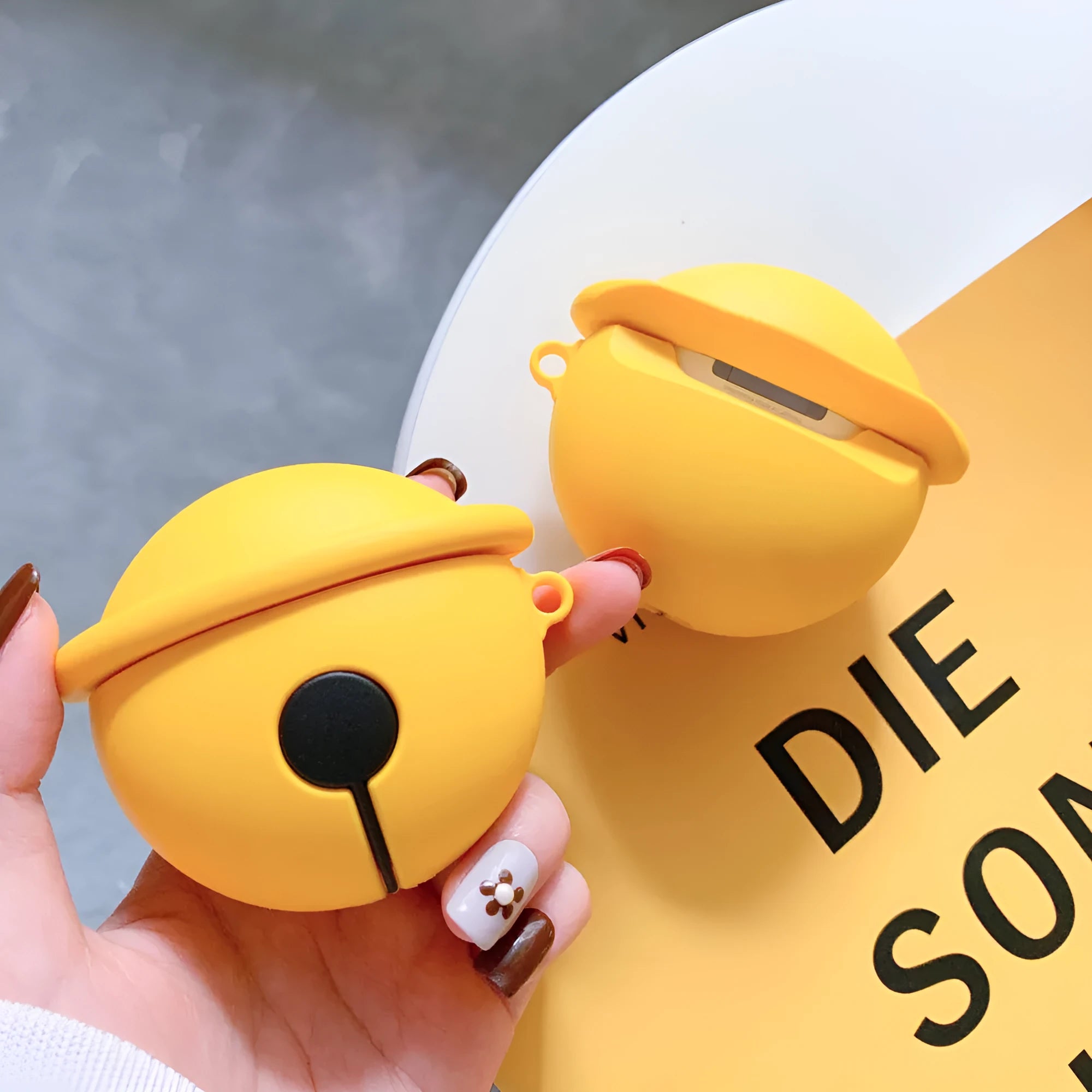 Yellow bell-shaped silicone protective case for Apple AirPods 1 and 2 headphones.