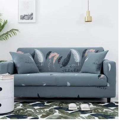 Geometric abstract printed stretch sofa slipcover covering a three-seater sofa with matching cushion covers.