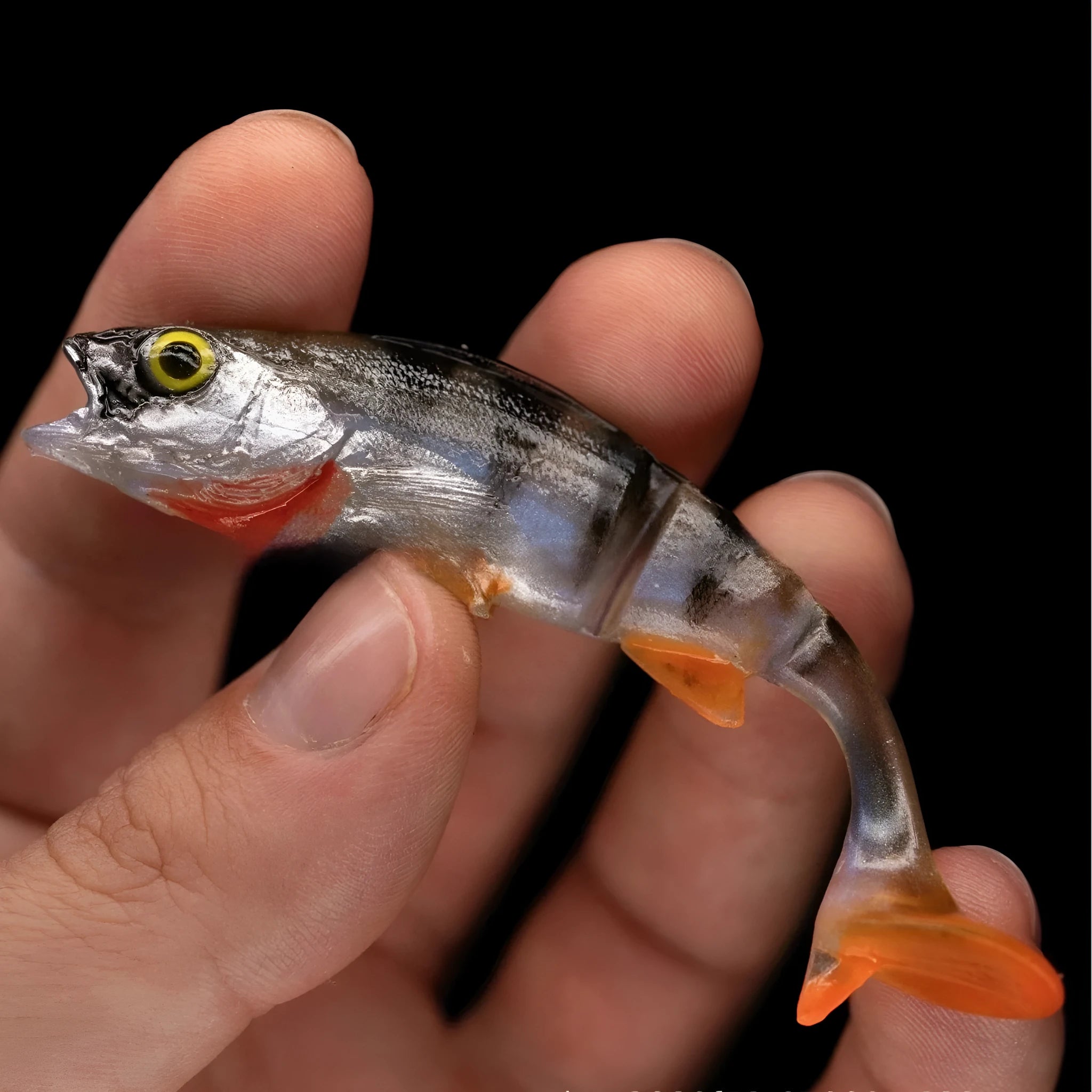 Soft sea fishing lure with T-tail design in natural fish colours showing textured scales and detailed fins