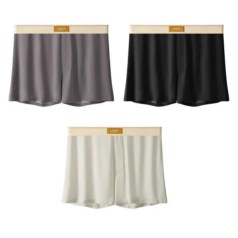Pack of three men's solid colour loose fit ice silk underwear briefs on a grey background.